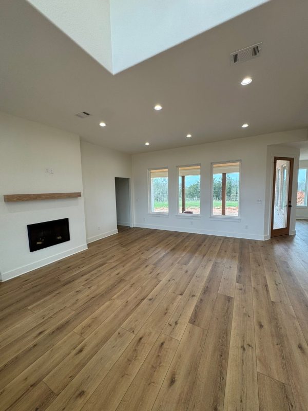 Unfurnished room with fresh light wood flooring and multiple windows letting in natural light.